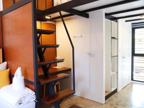 a room with a bunk bed and a staircase at Book a Bed Poshtel - SHA Plus in Phuket Town