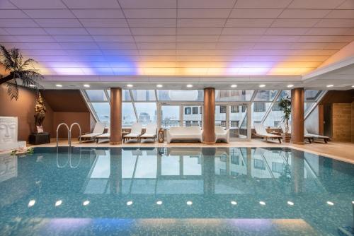 uma grande piscina no átrio do hotel com cadeiras em Grand Hotel Union Eurostars em Ljubljana
