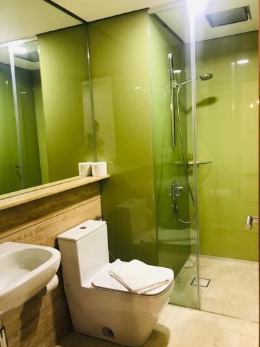 a bathroom with a toilet and a shower and a sink at Sky Suites KLCC by Luna KL in Kuala Lumpur