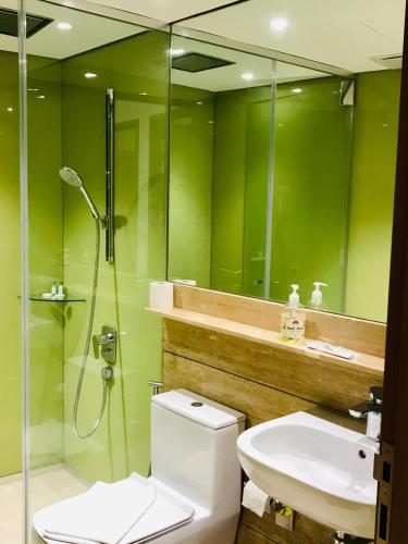 a bathroom with a toilet and a shower and a sink at Sky Suites KLCC by Luna KL in Kuala Lumpur