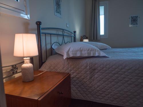 a bedroom with a bed with a lamp on a dresser at Apartments Hotel & Studios, Xifoupolis in Monemvasia