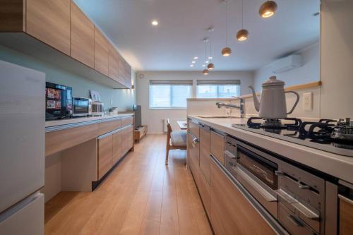a kitchen with a stove and a counter top at 新屋 札幌市中心薄野車程5分 廁所x2 浴室x1 可停車2台 高速Wi-Fi 對街超商 in Sapporo