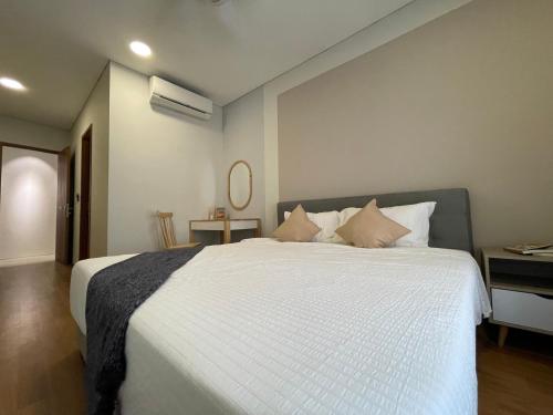 a bedroom with a large white bed with pillows at Sky Suites KLCC by Luna KL in Kuala Lumpur