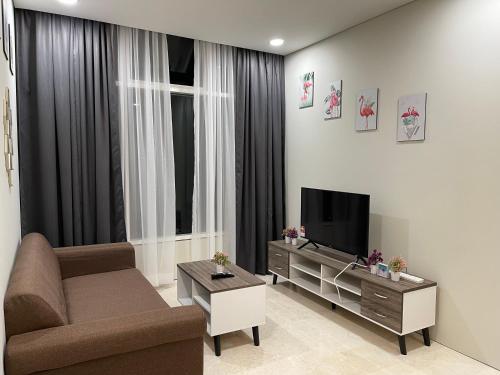 a living room with a couch and a television at Sky Suites KLCC by Luna KL in Kuala Lumpur