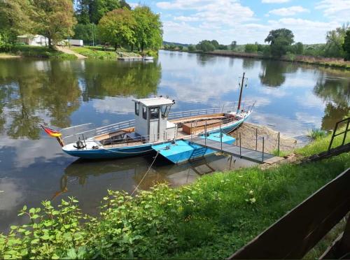 a small boat is docked on a river at Ferienwohnungen Grimma 3 in Grimma