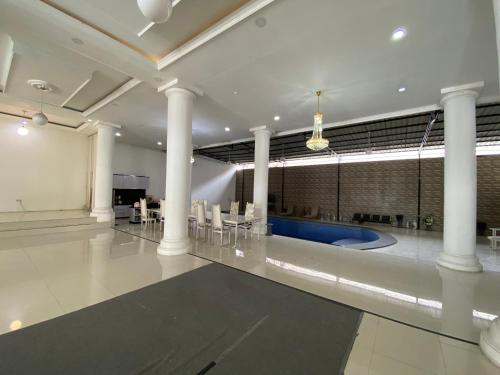 duży pokój z kolumnami i basenem w obiekcie Griya RW Family Guest House Redpartner w mieście Surakarta