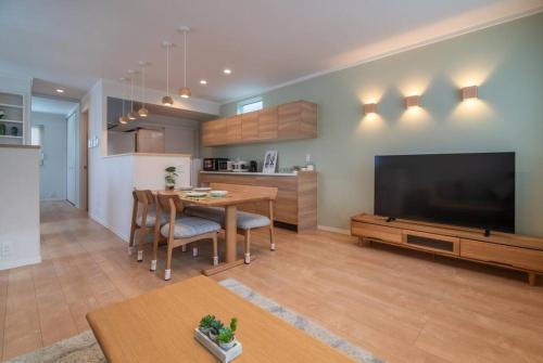 a living room with a large television and a table at 新屋 札幌市中心薄野車程5分 廁所x2 浴室x1 可停車2台 高速Wi-Fi 對街超商 in Sapporo