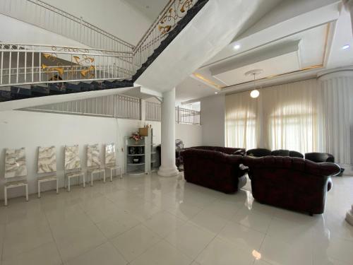 a large living room with couches and a staircase at Griya RW Family Guest House Redpartner in Solo