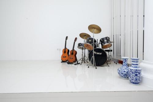 a group of guitars and other musical instruments in a room at Griya RW Family Guest House Redpartner in Solo