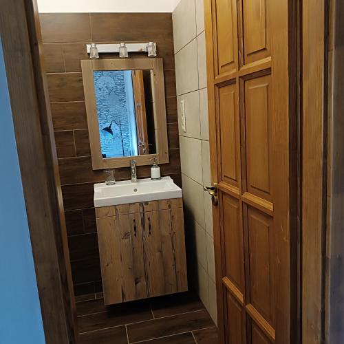 a bathroom with a sink and a mirror at Tekeres-patak Fogadó in Pálosvörösmart