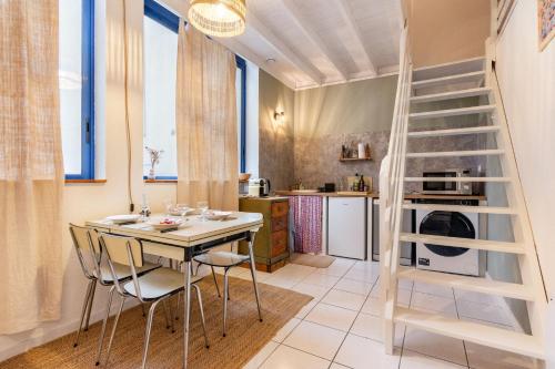 une cuisine avec une table, des chaises et une échelle dans l'établissement Duplex industriel sur l'île de Nantes, à Nantes
