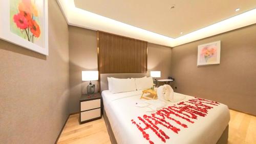 a bedroom with a large bed with a red blanket on it at Imperial KLCC Residence in Kuala Lumpur