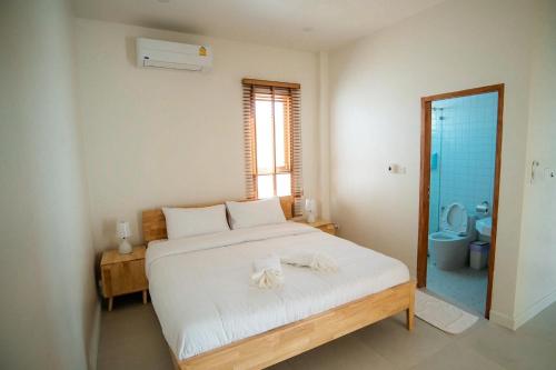 a bedroom with a bed and a bathroom with a toilet at Sunn Lay Pool Villa in Ban Hat Chao Samran