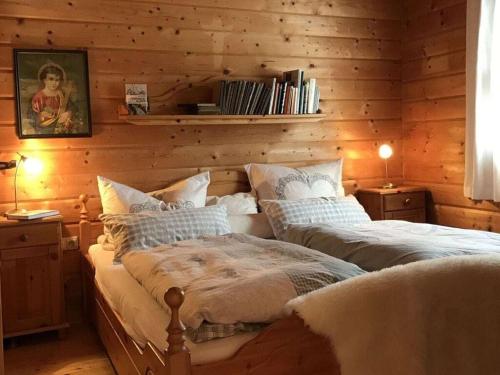 two beds in a room with wooden walls at The Karl Anton Hütte in Bodental