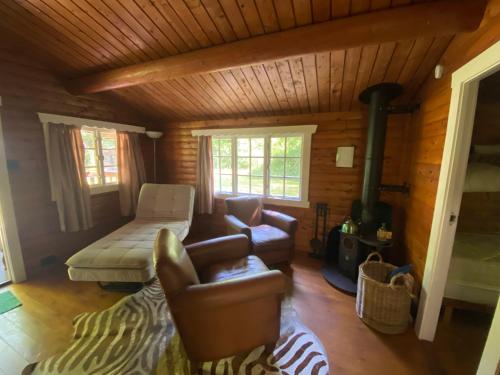 uma sala de estar com um sofá e um fogão em 3bears Log Cabin Whatstandwell Matlock Derbyshire em Crich