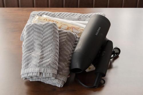 a hair dryer sitting on a table next to a towel at 子どもが主役の貸切宿 Villa Brave in Chichibu