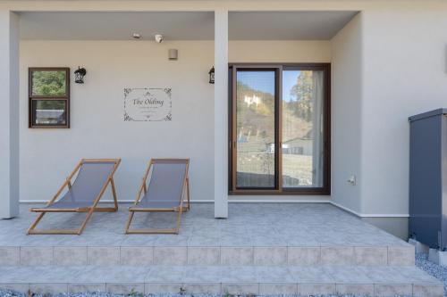 two blue chairs sitting on the patio of a house at 子どもが主役の貸切宿 Villa Brave in Chichibu