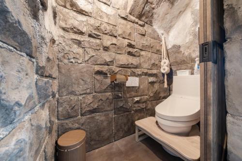 a stone walled bathroom with a toilet at 子どもが主役の貸切宿 Villa Brave in Chichibu