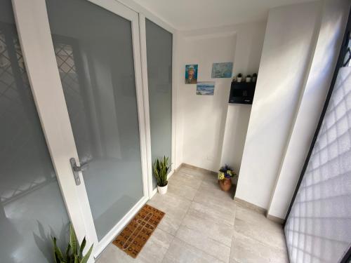 um corredor com uma porta de vidro com plantas em Loft Nineteen Apartment em La Spezia