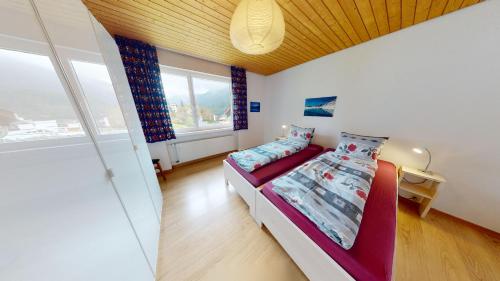 um quarto com uma cama e uma grande janela em Feriensiedlung True 7 em Scuol