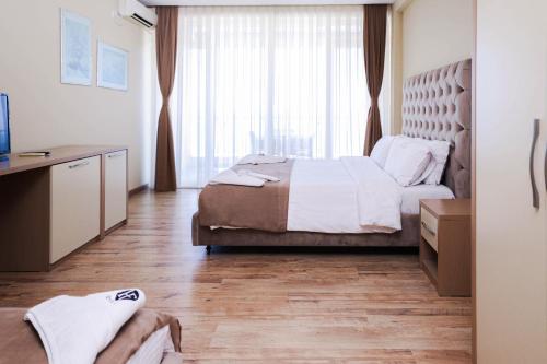 1 dormitorio con cama y ventana grande en Hotel Frojd - Beach Front Resort, en Shëngjin