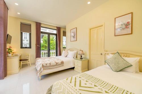 um quarto com 2 camas e uma secretária em The Sunshine Hoi An Villa em Hoi An