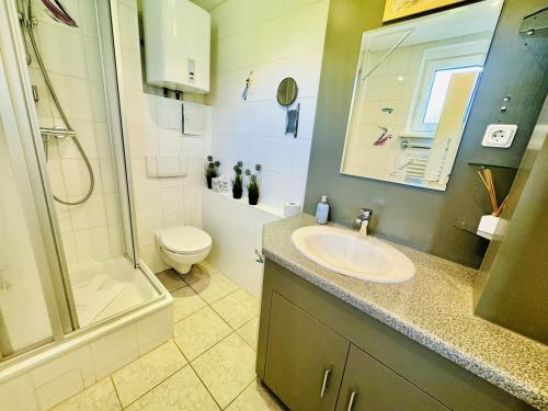 a bathroom with a sink and a shower and a toilet at Ferienhaus Matrose in Warnemünde