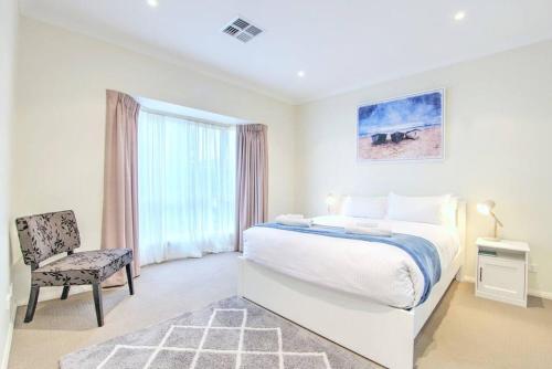 1 dormitorio blanco con 1 cama y 1 silla en No Stairsducted Ac Near Cbd Richmond Sa en West Richmond