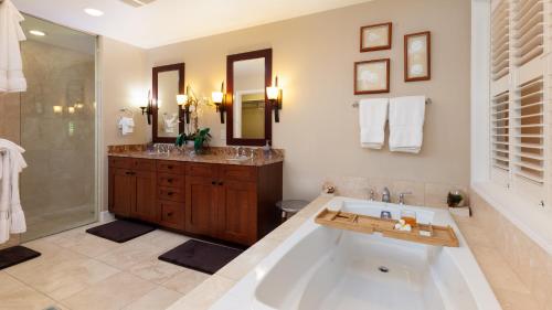 La salle de bains est pourvue d'une baignoire, d'une douche et d'un lavabo. dans l'établissement PLUMERIA HALE Exquisite 4BR KaMilo Home with Bikes and Beach Gear, à Waikoloa