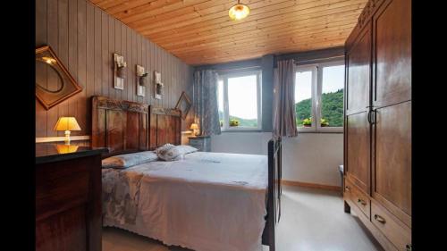 BorzonascaにあるCamere e accoglienza LA CASA DELLA NONNAの木製の天井が特徴のベッドルーム1室(ベッド1台付)