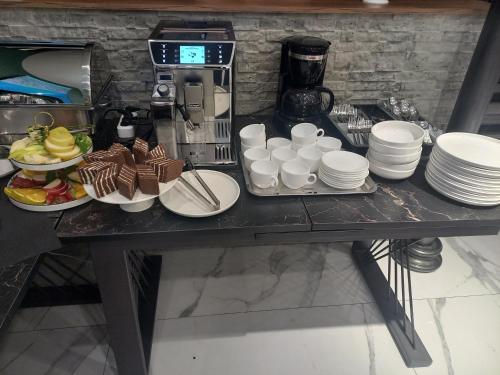 a table with plates and cups and dishes on it at Avenue 23 Boutique Hotel in Yerevan