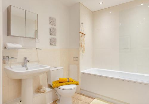 een badkamer met een wastafel, een toilet en een bad bij Inglewood in Ingleton 