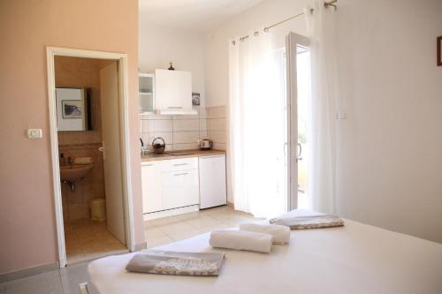 eine weiße Küche mit zwei Handtüchern auf dem Tisch in der Unterkunft Apartments Kresan in Zadar