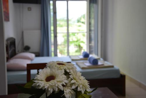 una sala de estar con una mesa y un jarrón de flores en Nakis Apartment Stavros en Stavros