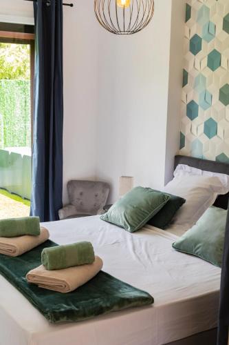 Elle comprend un grand lit avec des oreillers verts. dans l'établissement Villa paisible proche frontière espagnole avec piscine privée, à Les Cluses