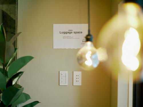 a light bulb hanging from a wall with a lightswitch at Akasaka Guesthouse HIVE in Tokyo