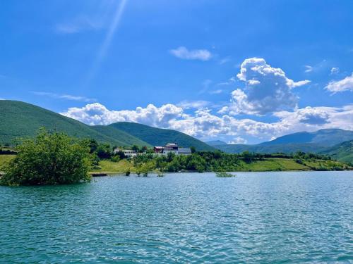 uma vista para um lago com montanhas ao fundo em SuperPanorama GuestHouse em Kukës