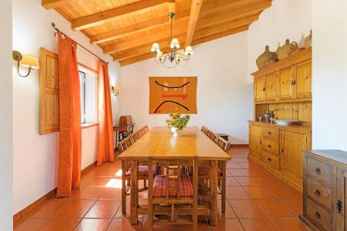 a kitchen with a wooden table in a room at Monte do Cerro Verde in Santiago do Cacém