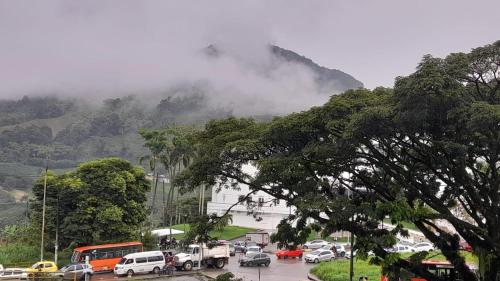 um parque de estacionamento com carros estacionados em frente a uma montanha em Hotel Go Pereira em Pereira