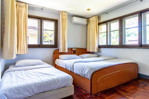 dwa łóżka w pokoju z oknami w obiekcie F4 Beach house Kitchen BBQ 3 bedrooms Large yard w mieście Rayong