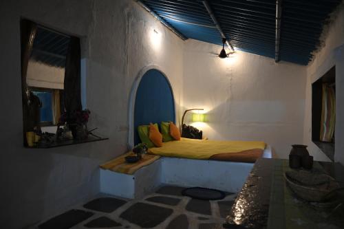 a bedroom with a bed in a white room at Bastar Birds Nest 