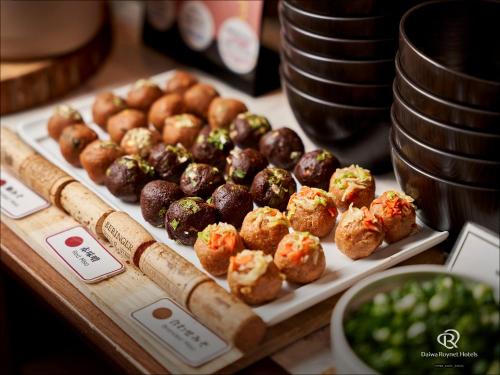 Una exhibición de muffins y panecillos sobre una mesa. en DEL style Nagoya Nayabashi by Daiwa Roynet Hotel, en Nagoya