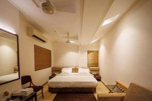 a bedroom with a bed and a couch and a mirror at Hotel Celebration in Jamnagar