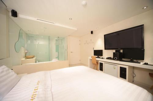 1 dormitorio con 1 cama y TV de pantalla plana en Jongno Hotel Pop Leeds Premier en Seúl