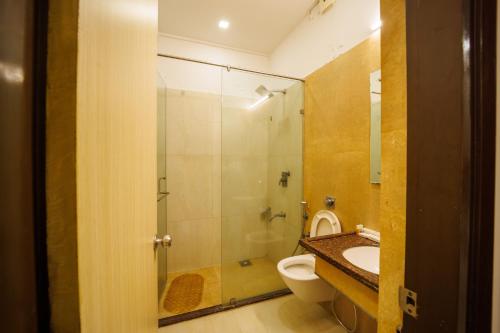 a bathroom with a shower and a toilet and a sink at Hotel Celebration in Jamnagar
