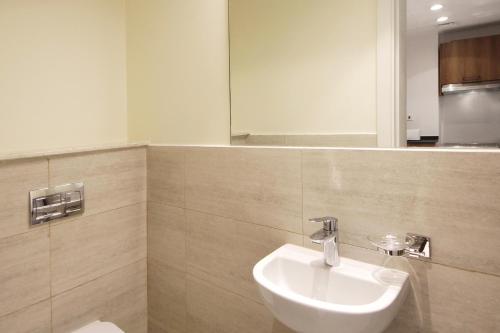 a bathroom with a sink and a mirror at Silk Valley - Modern 1br Pool And Gym Balcony in Al Qurayyah