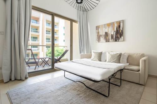 a living room with a bed and a couch at Frank Porter - Al Thayyal 2, The Greens in Dubai