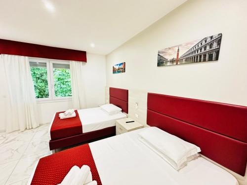two beds in a room with red and white at Dream Hub in Mestre