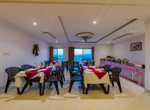 ein Esszimmer mit Tischen und Stühlen in einem Restaurant in der Unterkunft Hotel Mahabaleshwar Fragrance in Mahabaleshwar