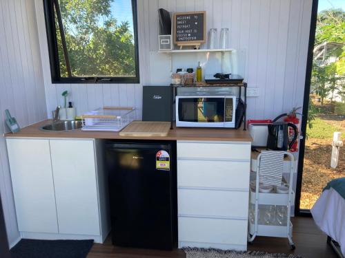 małą kuchnię z kuchenką mikrofalową i lodówką w obiekcie Sweet Retreat w mieście Bundaberg